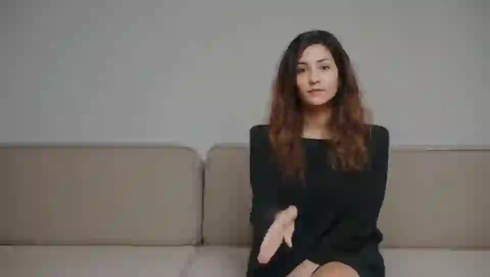 Woman sitting facing the camera, front view, symmetrical pose, centered on HunyuanVideo