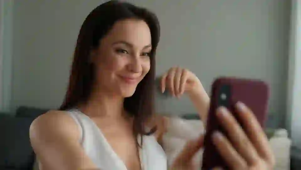 a woman taking a selfie, holding the phone with one on HunyuanVideo